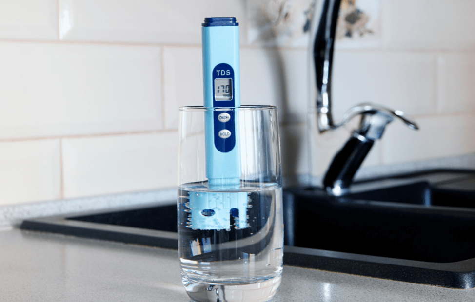 TDS Meter Dipped into Glass of Water on Countertop